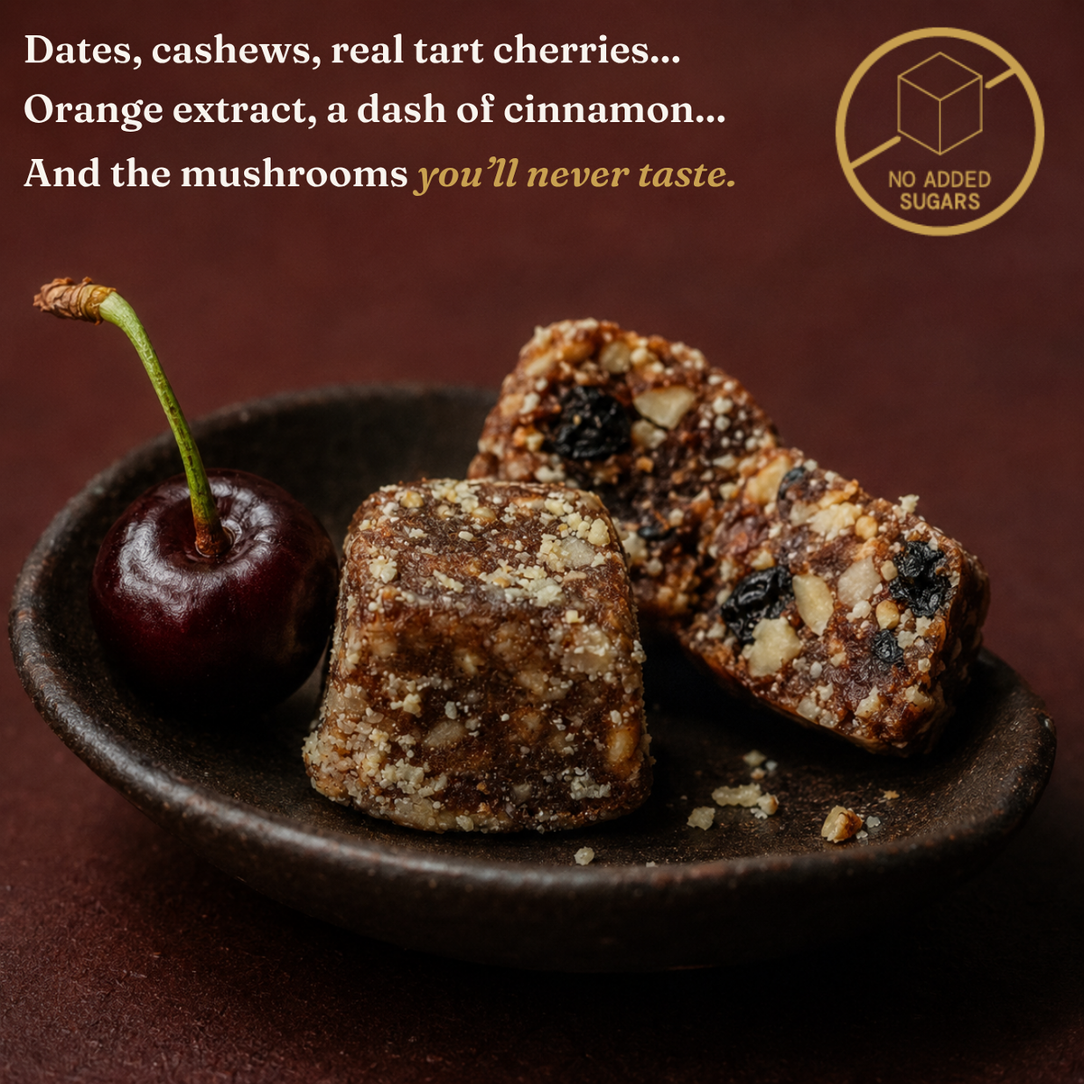 Three square dates-flavored energy bars with visible nuts and dried fruit pieces, served on a dark ceramic plate next to a whole tart cherry. Text at the top describes ingredients, and a gold badge says no added sugars.