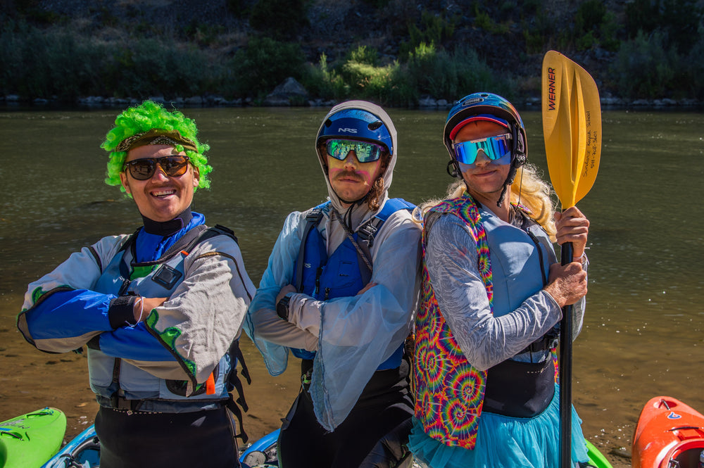 3 guys on a river getting ready to kayak