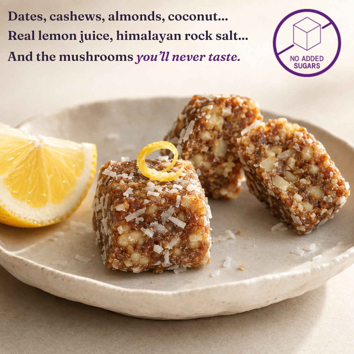 Three square date-flavored energy bites topped with shredded coconut and a lemon twist, served on a light beige ceramic plate with a lemon wedge. Text on the image lists ingredients like dates, cashews, almonds, coconut, and lemon juice, and a badge says 'No Added Sugars'.