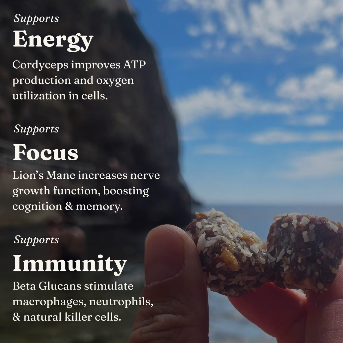 A close-up of a hand holding a coconut-coated energy snack bar in front of a scenic ocean and rock background, with text overlays highlighting benefits for Energy, Focus, and Immunity.