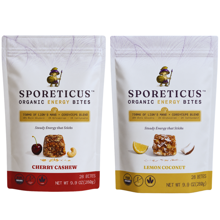 Two stand-up pouches of Sporeticus Organic Energy Bites on a white background. The left pouch is Cherry Cashew with a red bottom band and cherry/cashew imagery.